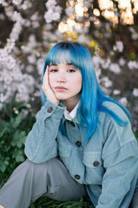 Portrait of a young woman against trees