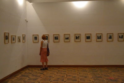 Rear view of woman standing against wall