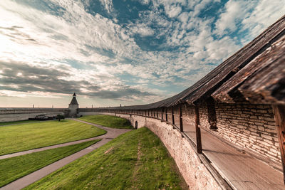 Footpath leading towards historic building against sky