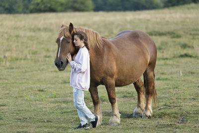 Woman with horse walking on field