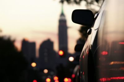 Close-up of cars on illuminated street in city against sky