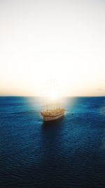 Sailboat in sea against clear sky