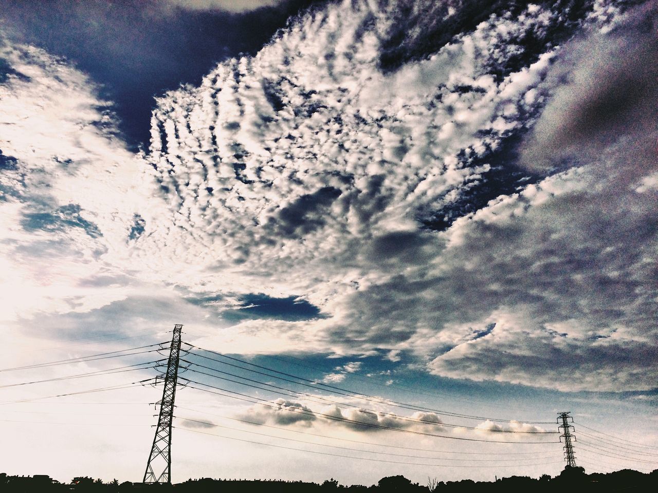 LOW ANGLE VIEW OF ELECTRICITY PYLON AGAINST SKY AT SUNSET