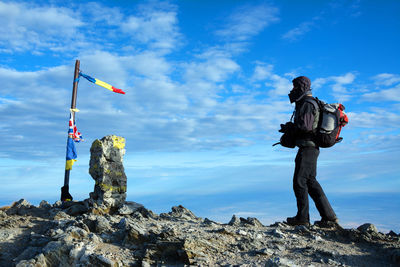 View of man standing on mountain against sky