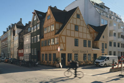 Cars on road by buildings in city