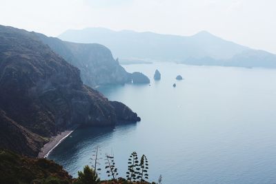 Scenic view of sea and mountains against sky