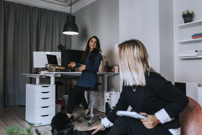 Woman using mobile phone while sitting on table