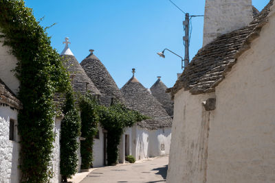 Alley amidst buildings against clear sky