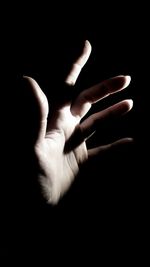 Cropped image of person gesturing on black background