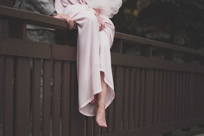 Low section of woman standing by railing