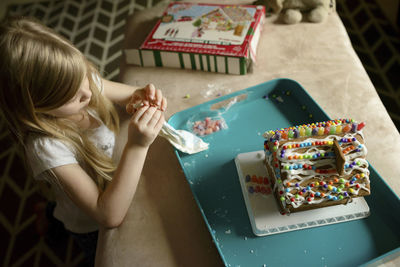 High angle view of girl decorating toy house