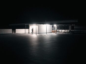 People walking in illuminated parking lot at night