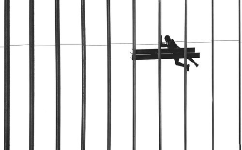 Low angle view of man working on glass window