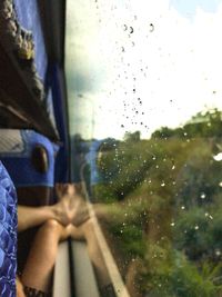 Close-up of wet glass window of train