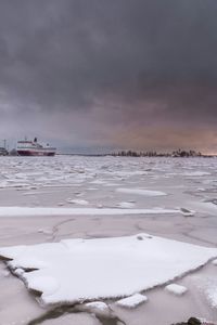 Scenic view of snow covered landscape against cloudy sky