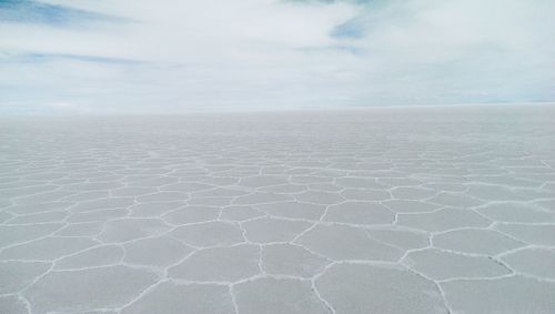 Idyllic view of salar de uyuni against cloudy sky