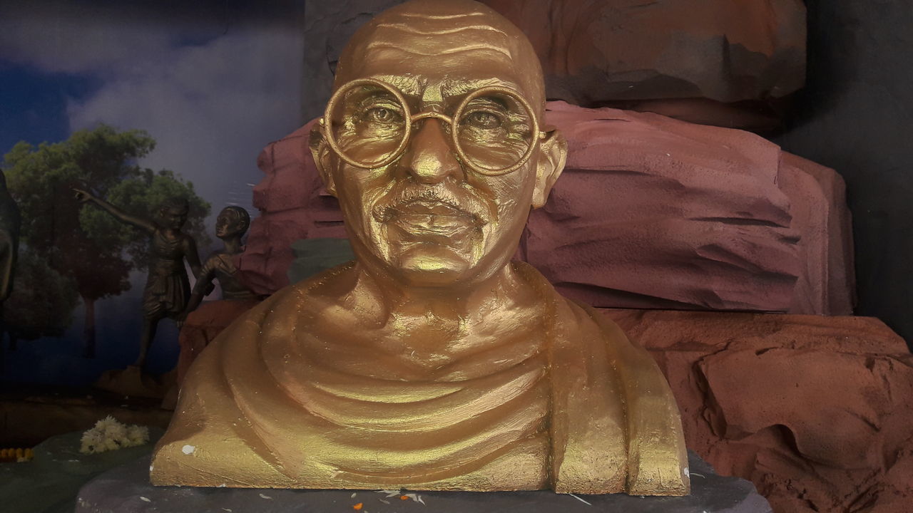 CLOSE-UP OF BUDDHA STATUE AGAINST WALL