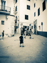 People walking on street amidst buildings in city