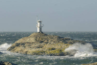 Lighthouse by sea in stormy weather.