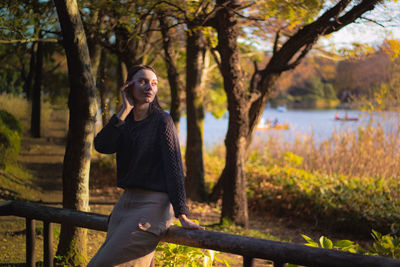 Side view of young woman standing in park