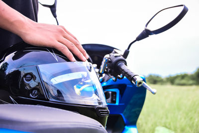 Cropped hand of man with helmet and motorcycle