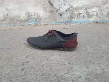 High angle view of shoe on sand on sidewalk 