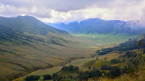 Scenic view of field and mountains against sky