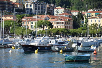 Boats moored in harbor by buildings in city