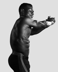 Side view of young man looking away against white background