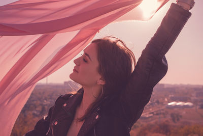 Portrait of young woman looking at sunset