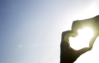 Low angle view of person hand against bright sun