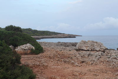 Rocks by sea against sky