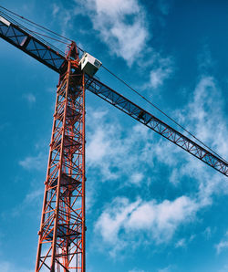 Low angle view of crane against cloudy blue sky
