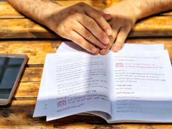 Midsection of person reading book on table