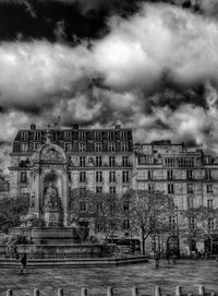 Buildings against cloudy sky
