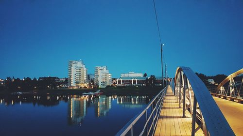 Panoramic view of bridge in city against clear blue sky