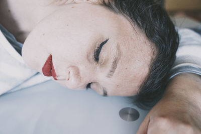 Close-up portrait of woman lying down on bed