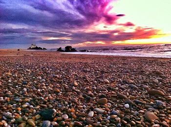 Surface level of beach against cloudy sky