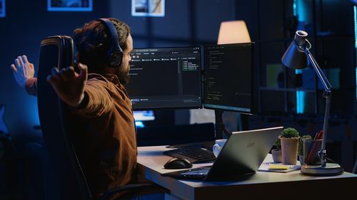 Rear view of woman using laptop on table