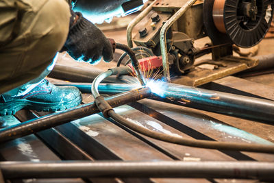 Close-up of man working on metal in factory