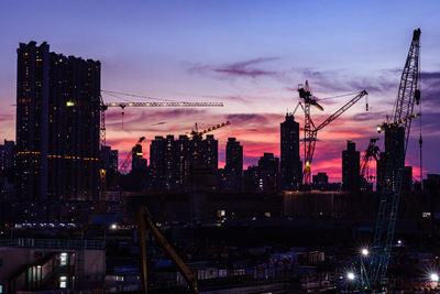 Illuminated cityscape against sky at night