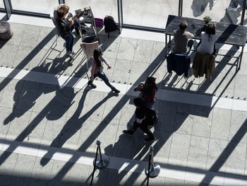 High angle view of people walking on tiled floor