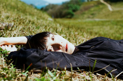 Rebel young woman lying down on field