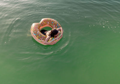Girl in her inflatable buoy in the middle of a lake