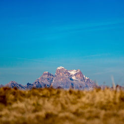Surface level of rocky mountain against blue sky