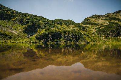 Scenic view of lake and mountains against sky