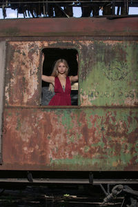 Portrait of young woman standing in abandoned train