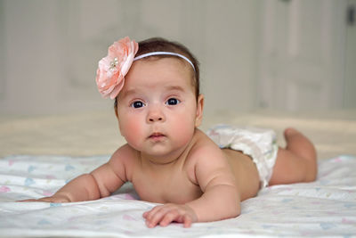 Portrait of cute baby boy lying on bed at home