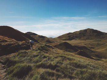 Man walking on mountain against sky