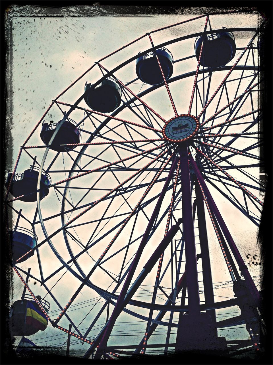 transfer print, low angle view, amusement park ride, ferris wheel, amusement park, auto post production filter, arts culture and entertainment, sky, built structure, architecture, silhouette, outdoors, metal, day, no people, dusk, clear sky, fun, cloud - sky, building exterior